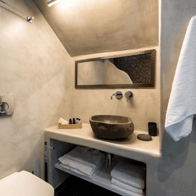 One Bedroom Suite bathroom with a stone vessel sink and folded towels
