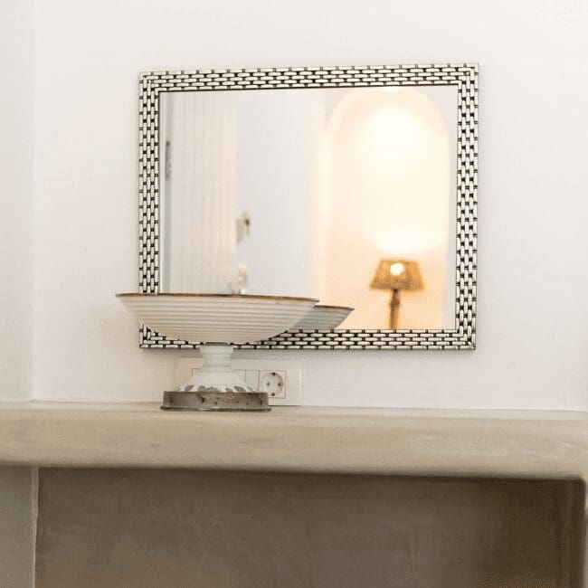 Decorative console with a framed mirror and lamp in a Standard Suite