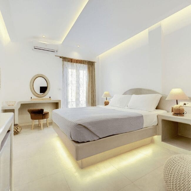 Standard Suite with a double bed, vanity and round mirror