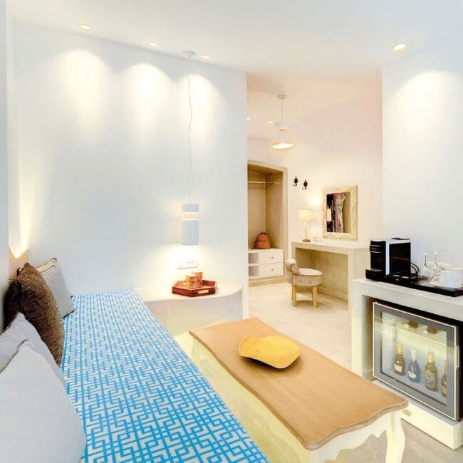 Open-plan Suite with Pool View showing a built-in sofa, minibar and dressing area