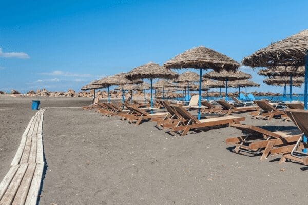 Monolithos organised black-sand beach with straw umbrellas, sunbeds and a boardwalk, Santorini
