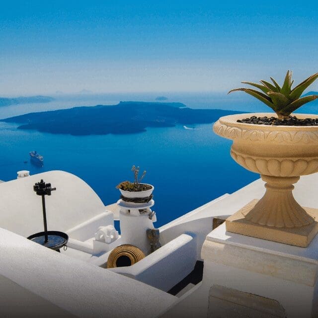 Whitewashed rooftop with an urn planter overlooking the Santorini caldera