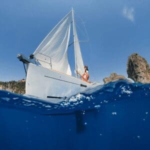 Sailing yacht cruising the deep blue Aegean waters off Santorini