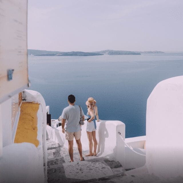 Couple enjoying the caldera view from whitewashed steps in Santorini