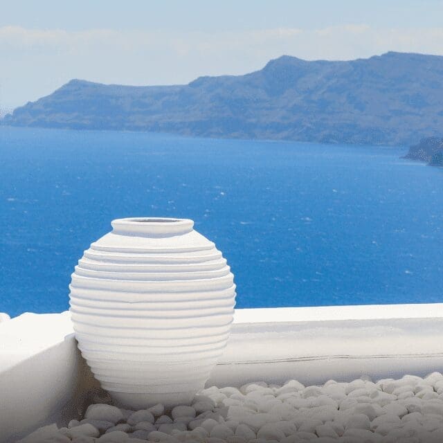 White Cycladic urn overlooking the Santorini caldera and Aegean Sea